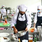 Home Chefs in masks preparing food in a commercial kitchen, emphasizing hygiene and teamwork.